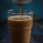 Straining masala tea through a tea strainer.