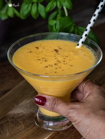 holding a glass with Indian Mango drink