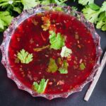 Rasam served in a glass bowl as a soup.