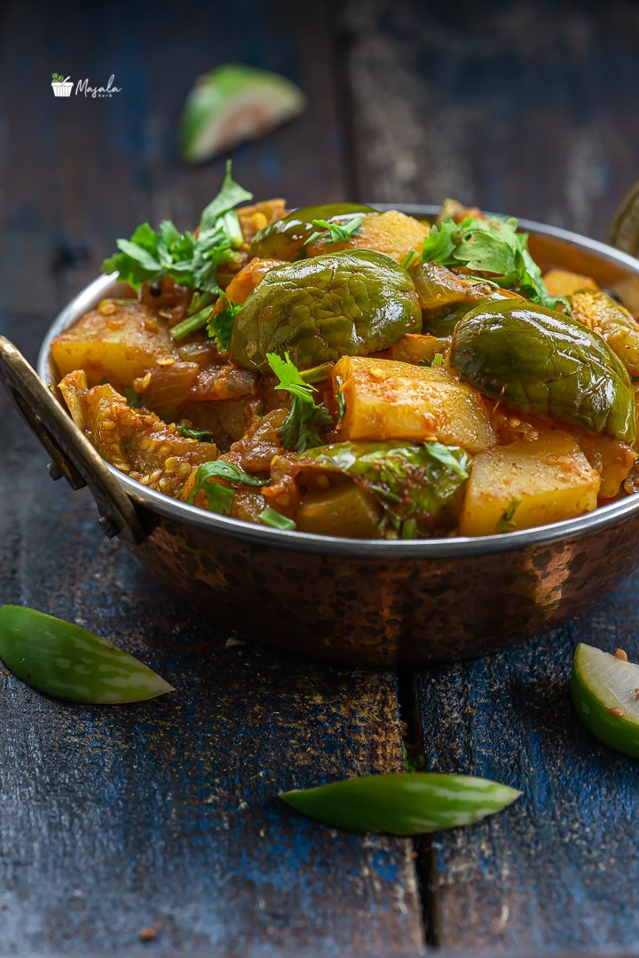 Close up view of aloo baingan sabzi/Green Eggplant Potato Curry.