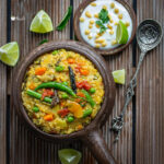 Khichdi served in a bowl with raita one the side