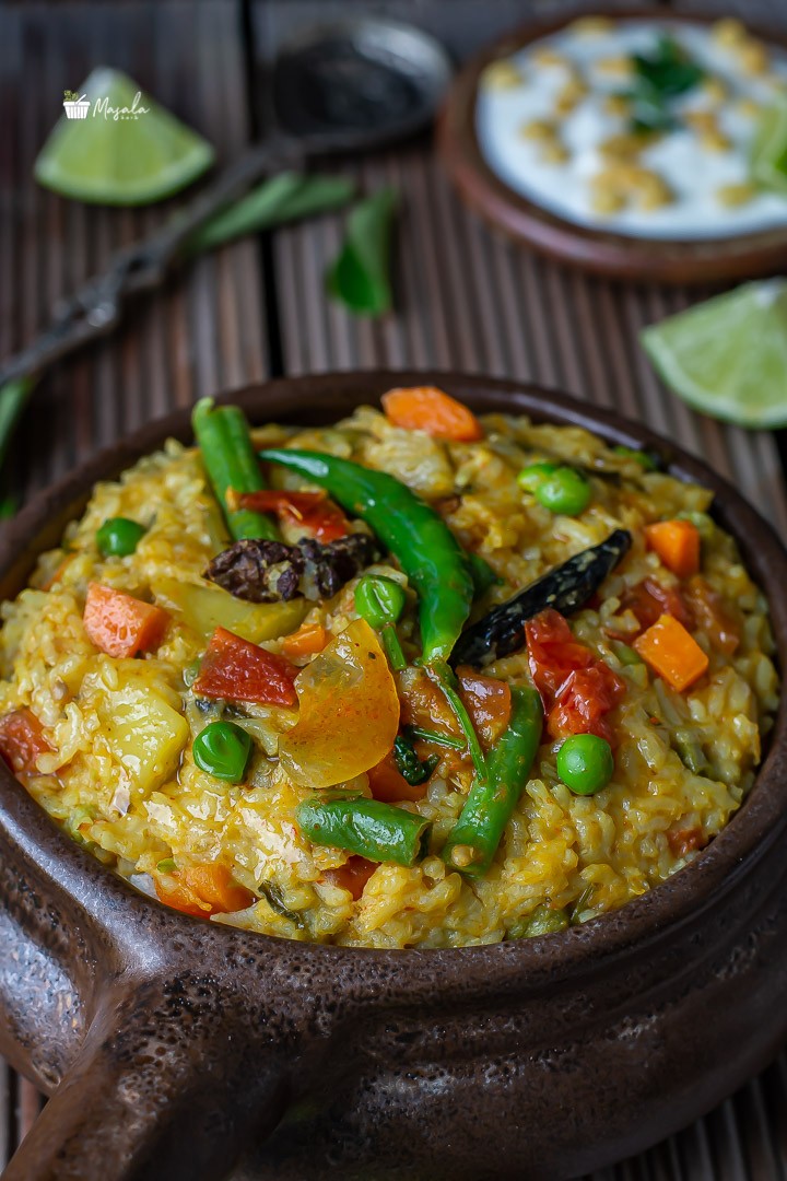 Close up view of khichdi with green chillies on top