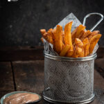 Crispy Masala French Fries served in a tin.