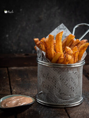 Crispy Masala French Fries served in a tin.