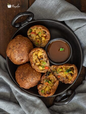 Potato Bread Rolls Recipe Indian - Bread Bonda Recipe served on a black plate