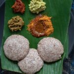 Ragi Idli served with an array of side dishes on a banana leaf