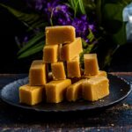 A stack of ghee mysore pak on a black plate