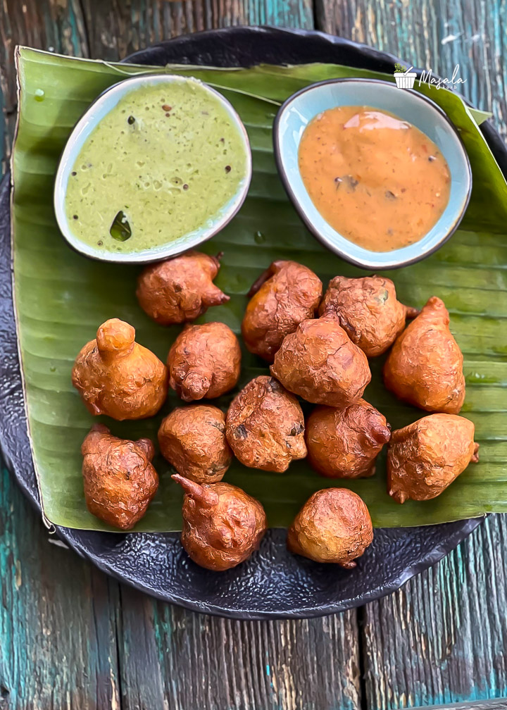 Goli baje served on a banana leaf with chutneys.