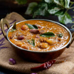 Small onion curry served in a copper kadai.