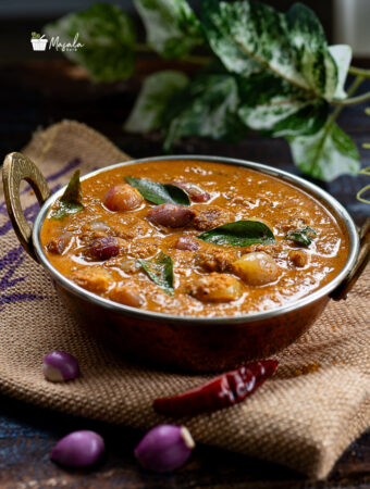 Small onion curry served in a copper kadai.